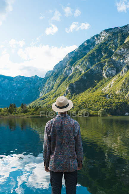 Hombre de pie en el lago - foto de stock