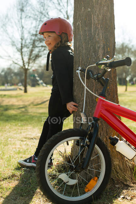 Chica descansando después de montar su bicicleta en el parque - foto de stock