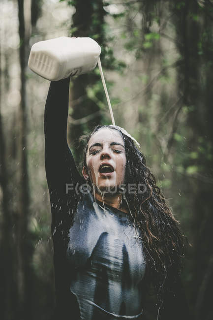 Mujer vertiendo leche sobre la cara - foto de stock