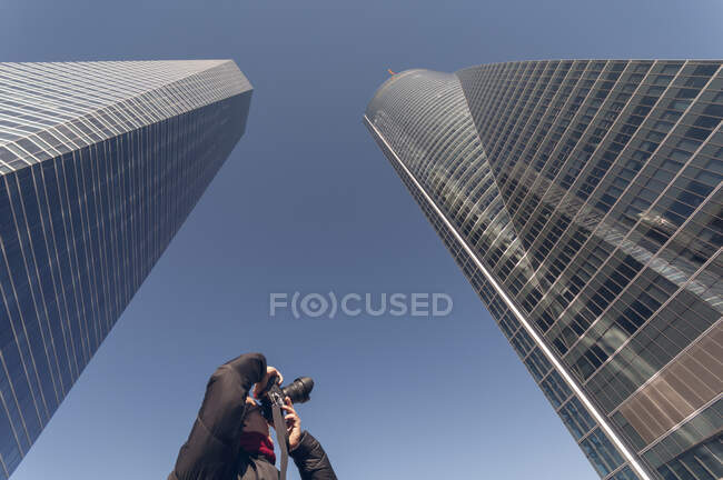 Homme prenant des photos de gratte-ciel dans le centre financier — Photo de stock