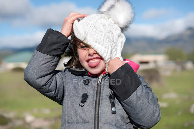 Close-up de uma menina com boné de lã e cachecol no campo — Fotografia de Stock