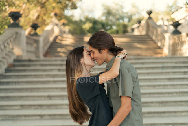 Портрет молодой пары, обнимающей друг друга лицом к лицу на лестнице . — стоковое фото