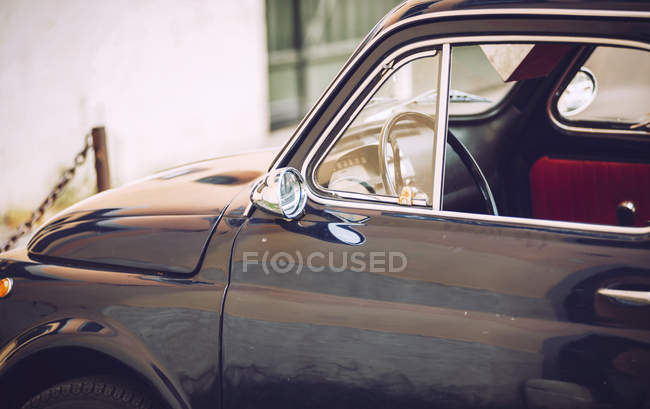 Crop image of parked vintage black car at street scene — Stock Photo