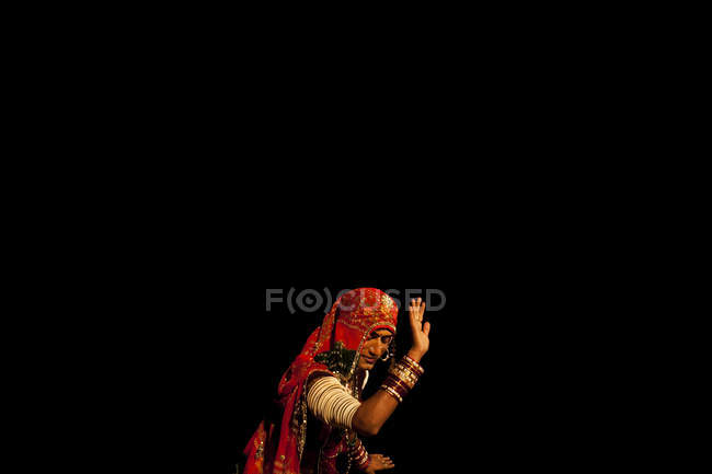 Индия - 12 октября 2011 года: Человек в традиционной одежде и танцах на черном фоне , — стоковое фото