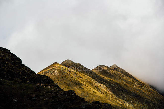 Paesaggio di montagne verdi sotto il cielo nebbioso — Foto stock
