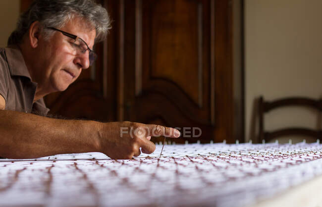 Hombre trabajando con un tapiz - foto de stock