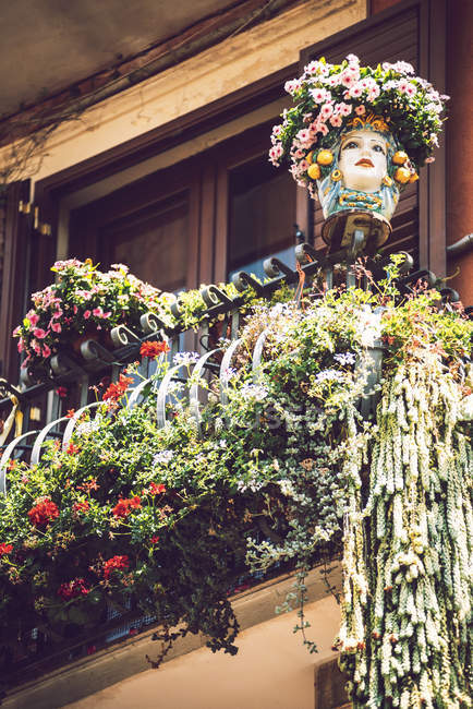 Vue à angle bas du balcon décoré de plantes en pot et masque — Photo de stock