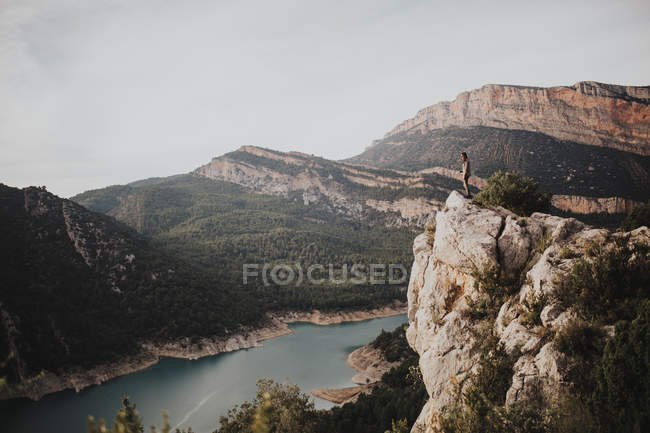 Vue lointaine du randonneur debout sur la roche contre de beaux paysages de montagne — Photo de stock