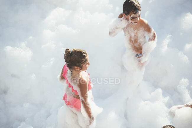 Children playing in foam — Stock Photo