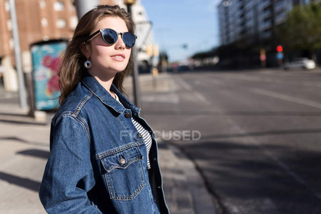 Happy woman in sunglasses posing on walkside — Stock Photo