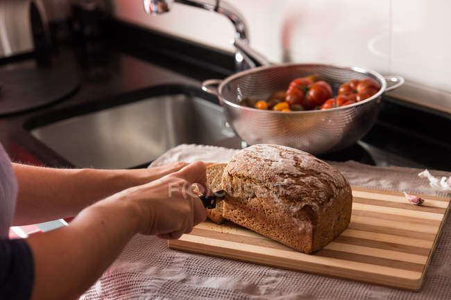 Женщина, режущая хлеб — стоковое фото
