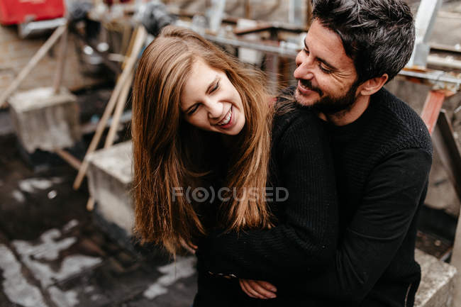 Бородатий чоловік обіймає блондинку дівчину ззаду — стокове фото
