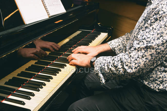 Cultivo manos masculinas tocando teclas de piano - foto de stock