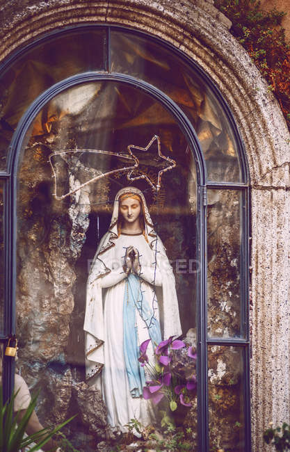 Virgin Mary statue behind glass — Stock Photo