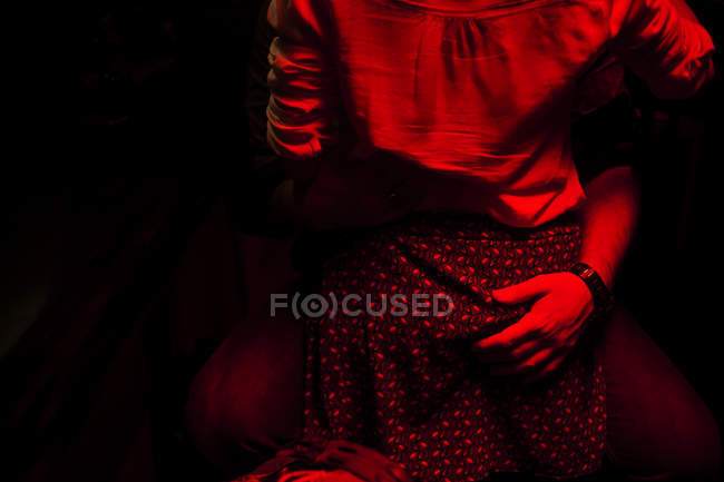 Обратный вид женщины в объятиях мужчины, держащегося за руки на бедрах . — стоковое фото