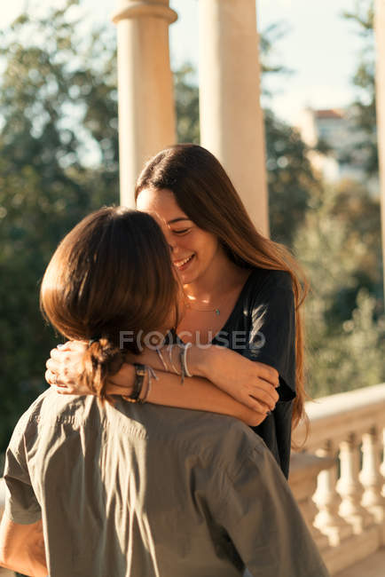 Retrato de namorada sorridente abraçando em torno do pescoço namorado — Fotografia de Stock