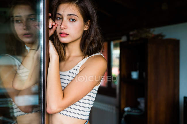 Mulher bonita inclinada no armário e olhando para a câmera — Fotografia de Stock