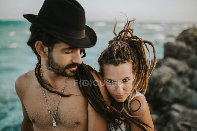 Portrait of embracing happy couple on ocean rocky shore — Stock Photo