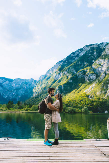 Casal abraçando no lago da montanha — Fotografia de Stock