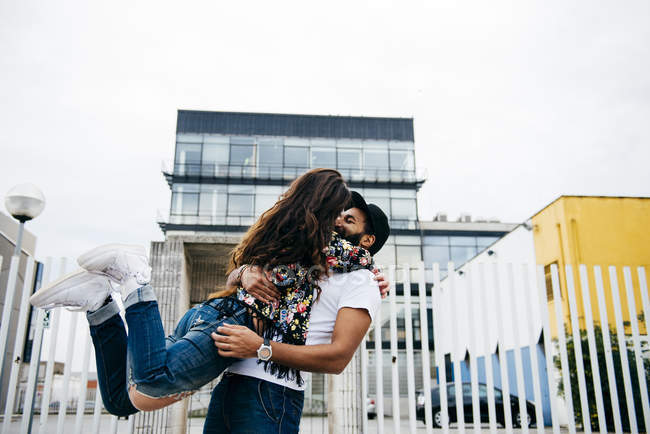 Mädchen hängt an Mann und küsst ihn — Stockfoto