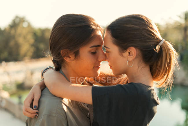 Portrait of sunlit sensual couple touching each one with noses — Stock Photo