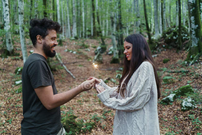 Paar mit Wunderkerzen im Wald — Stockfoto