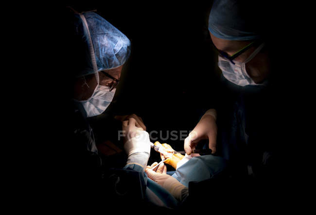 Retrato de dois cirurgiões que prestam cirurgia no tornozelo na clínica — Fotografia de Stock