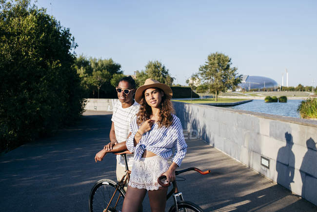 Пара опирающихся на велосипед в городском парке — стоковое фото