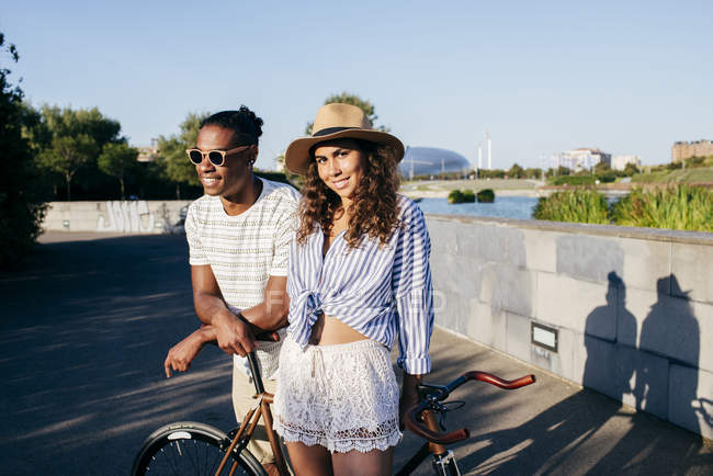 Couple leaning on bicycle at urban park — Stock Photo