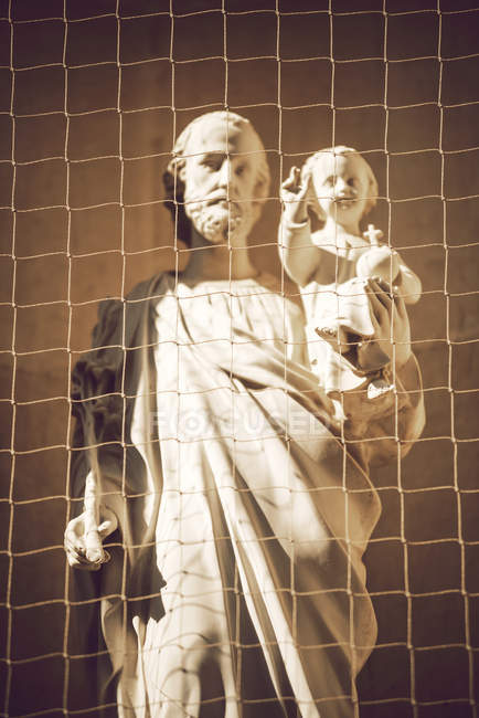 Detalle de la estatua de San José tras la rejilla - foto de stock