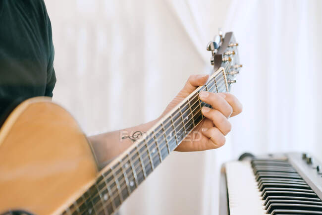 Молодой человек записал гитары и фортепиано в своей домашней звуковой студии. — стоковое фото