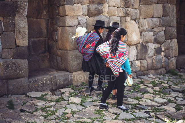 AYACUCHO, PÉROU - 30 DÉCEMBRE 2016 : Vue de dos d'un groupe de femmes marchant dans des ruines antiques — Photo de stock