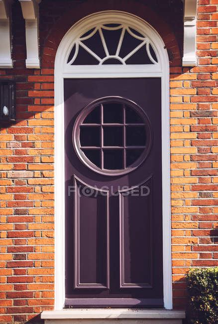 Porta roxa com janela redonda — Fotografia de Stock