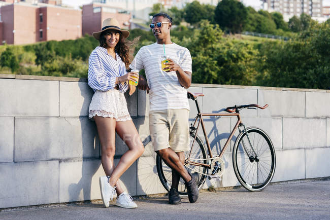 Paar mit Getränken und Fahrrad — Stockfoto