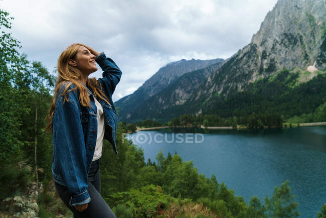 Femme debout au lac de montagnes — Photo de stock