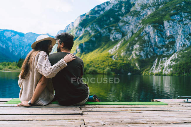 Casal sentado no lago e olhando um para o outro — Fotografia de Stock