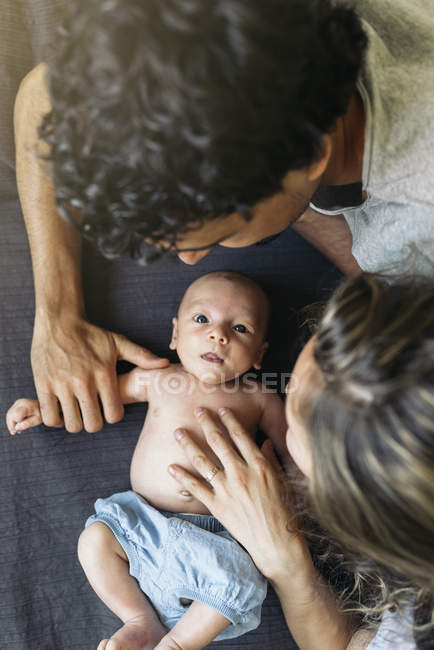 Feliz jovem casal massageando filho recém-nascido — Fotografia de Stock