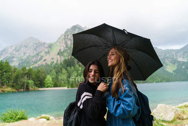 Women under umbrella in mountains — Stock Photo