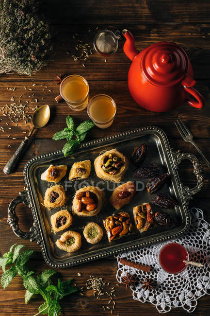 Diretamente acima sobremesas de knafeh na chapa com copos de chá . — Fotografia de Stock
