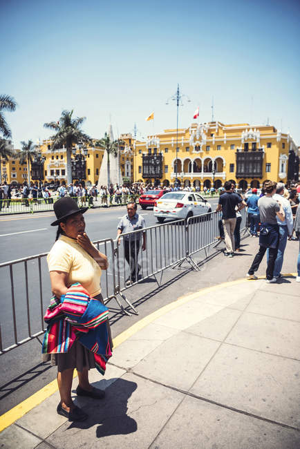 LIMA, PERU - 26 DICEMBRE 2016: Donna in piedi sulla scena di strada sullo sfondo del Municipio — Foto stock