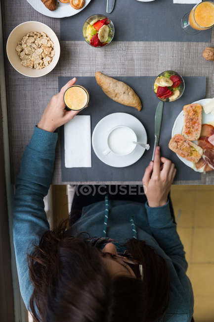 Vista superior de la chica desayunando en la mesa de café - foto de stock