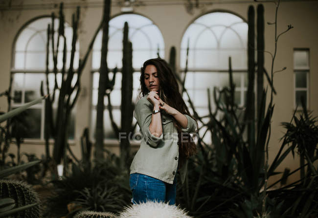 Chica sensual posando con los ojos cerrados en el jardín botánico - foto de stock