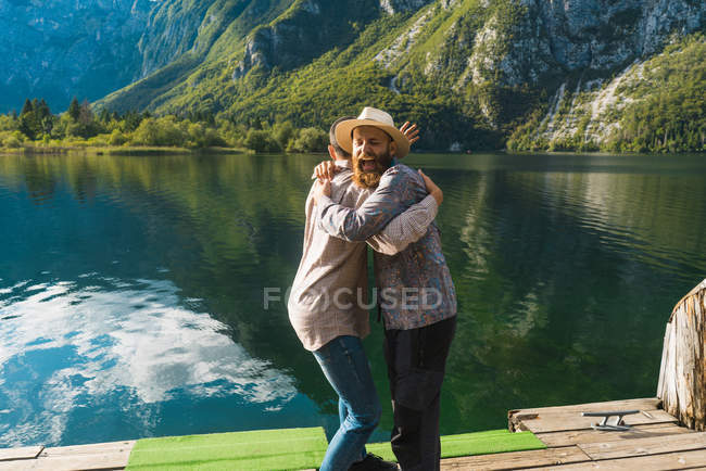 Friends embracing on wooden pierce — Stock Photo