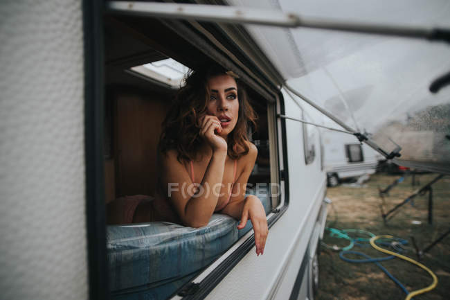 Женщина в нижнем белье смотрит в окно — стоковое фото