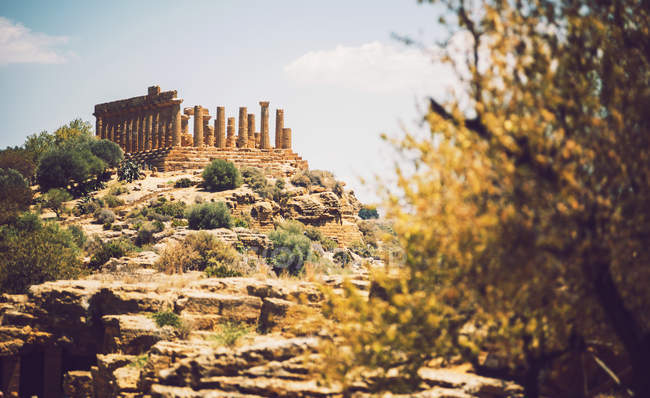 Sunlit ancient ruins on hill over sky — Stock Photo
