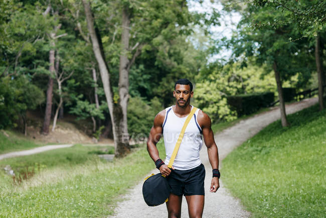 М'язистий чоловік ходить в парку — стокове фото