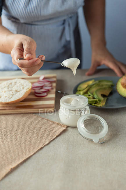 Person scooping sauce from jar — Stock Photo