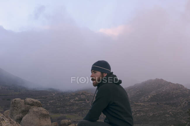 Человек в шляпе в горах холодный и облачный день — стоковое фото