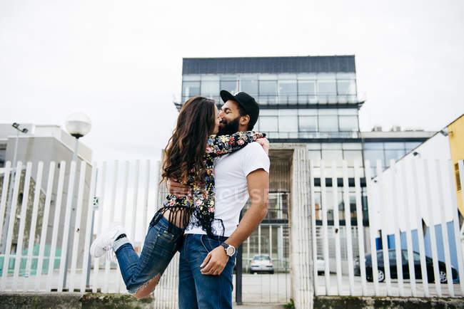 Brünette Mädchen hängen an Mann und küssen — Stockfoto