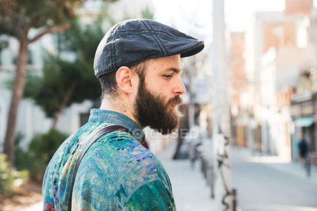Вид збоку бородатого чоловіка в джинсовій шапці на вуличній сцені — стокове фото